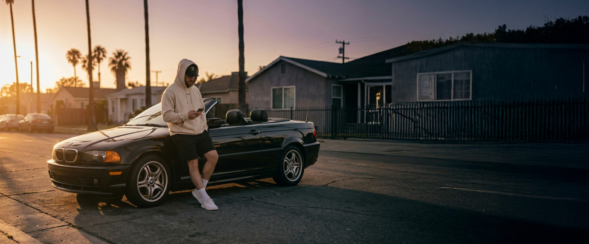 Hoodie IRONIK porté près d’une BMW cabriolet au coucher du soleil
